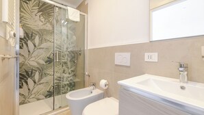 A modern bathroom with a glass shower enclosure, a bidet, and a large sink. - Double bed and sofa bed with private bathroom 3-4 people - 20 minutes from Milan (Trezzano sul Naviglio)