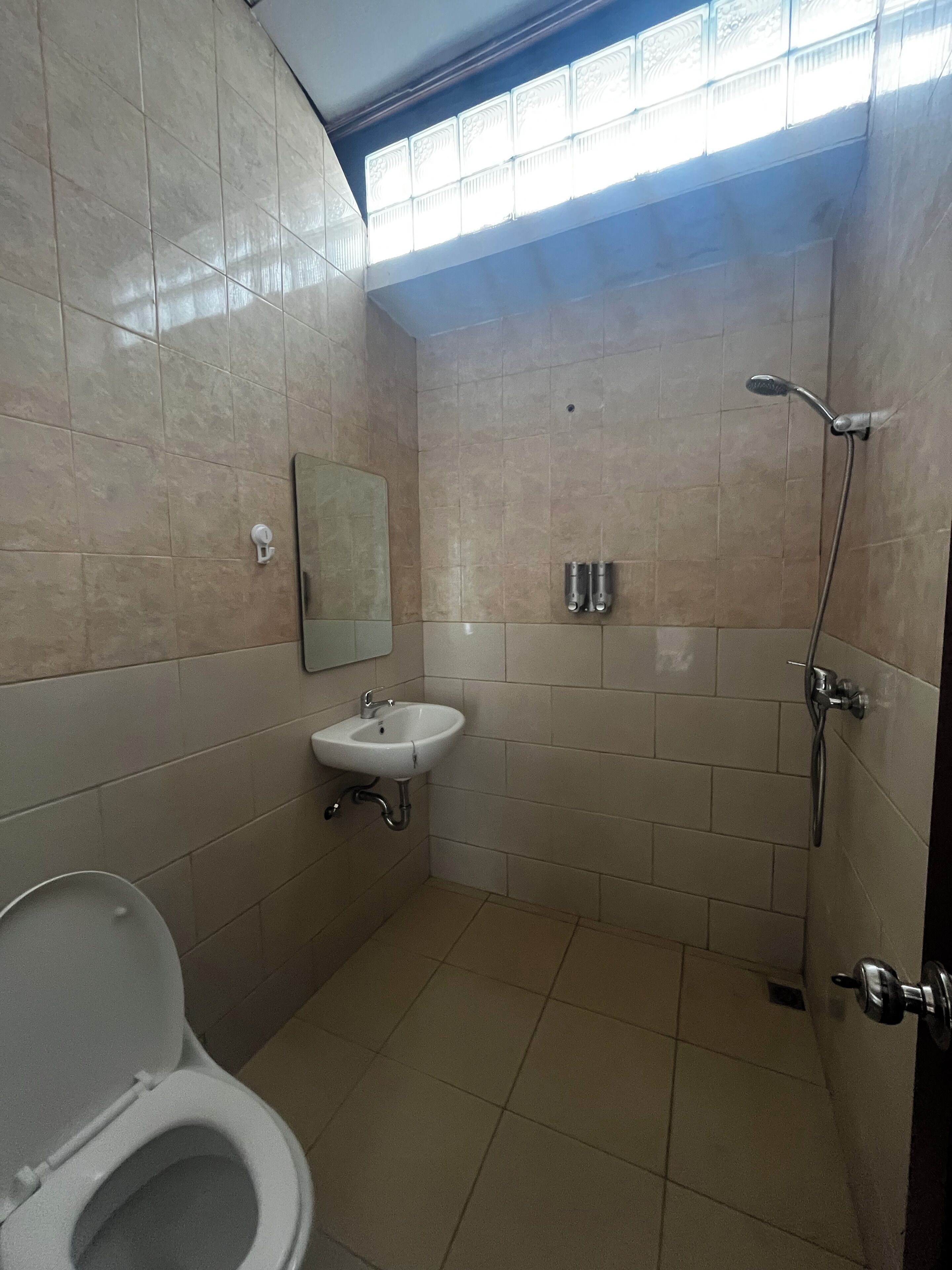Een badkamer met toilet, wastafel en douche.