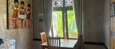 A dining area with a table and chairs, a water dispenser, and a painting on the wall.