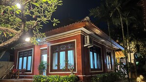 A traditional house with a tiled roof, large windows, and a well-maintained garden. - Villa Tiga Naga Sanur (Denpasar)