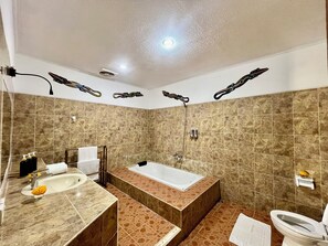 A bathroom with a bathtub, sink, and toilet. - Villa Tiga Naga Sanur (Denpasar)