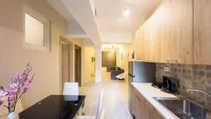 Eine moderne Küche mit Holzausstattung, einer schwarzen Arbeitsplatte und einem Edelstahl-Spülbecken.