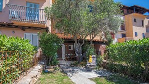 Un patio con un sendero de piedra, un comedor y una zona de estar cubierta.