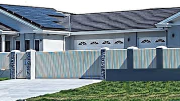 A two-story house with a garage, solar panels, and a gated driveway.