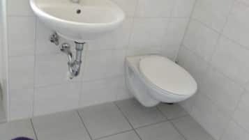 Een douche, handdoeken, zeep, toiletpapier