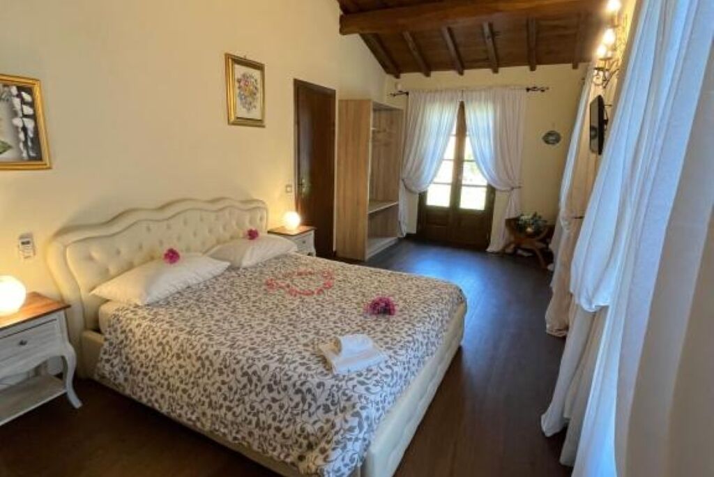 A bedroom with a bed, bedside tables, a wardrobe, and a window with curtains.
