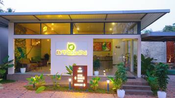 A modern building with a sign indicating a lobby, office, business center, and NESTO cafe.
