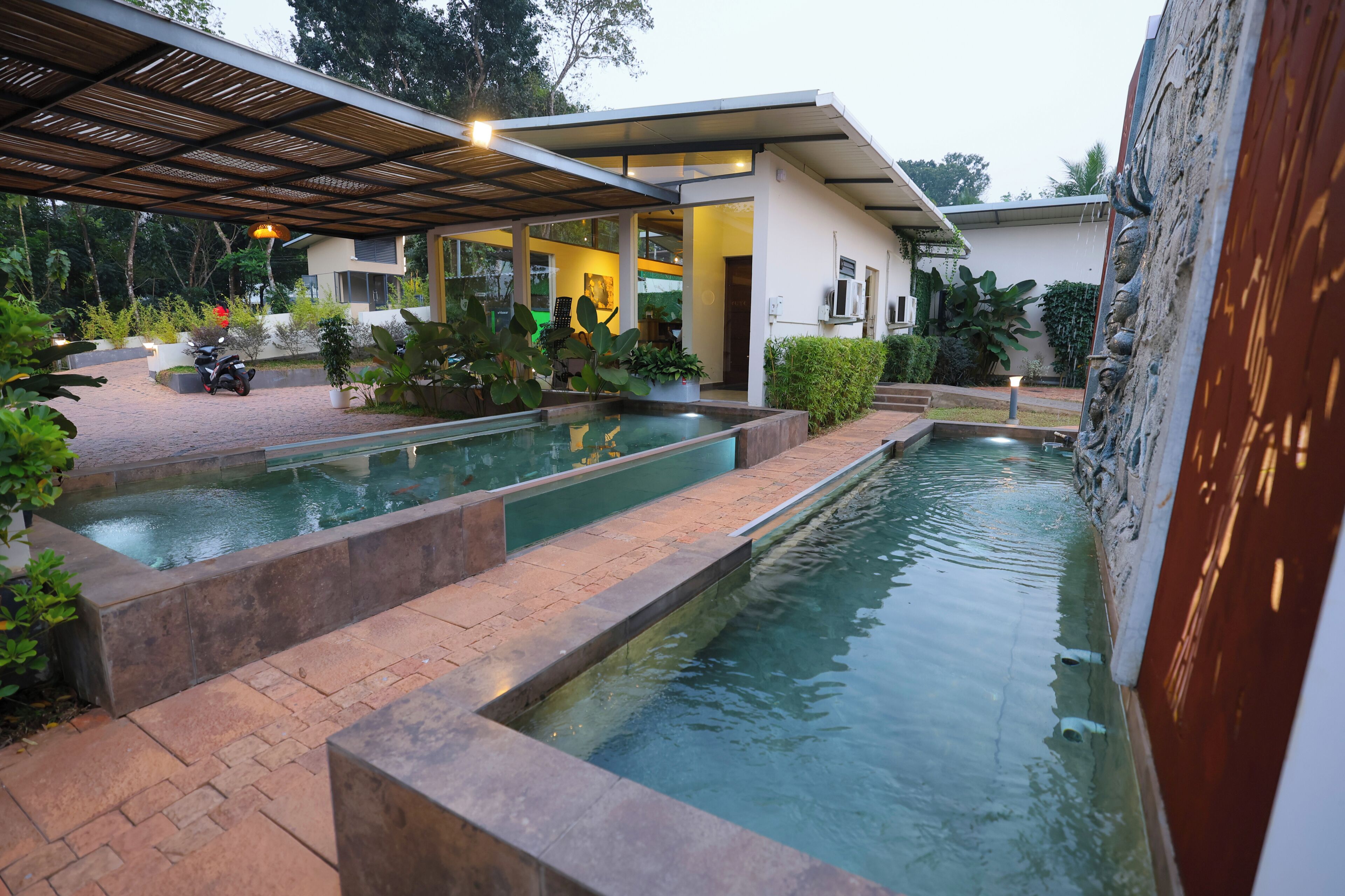Una casa moderna con piscina, un patio cubierto y jardín.