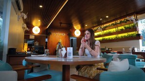 Een restaurant met houten plafond, groene planten en een bord waarop 'YUTORI' staat.