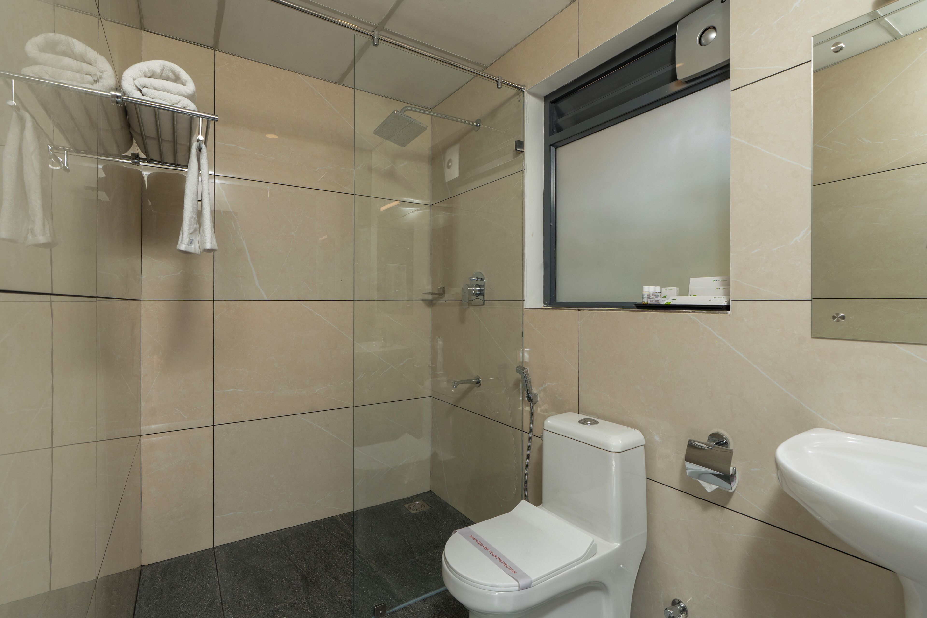 Une salle de bain moderne avec une douche à parois de verre, des toilettes et un lavabo.