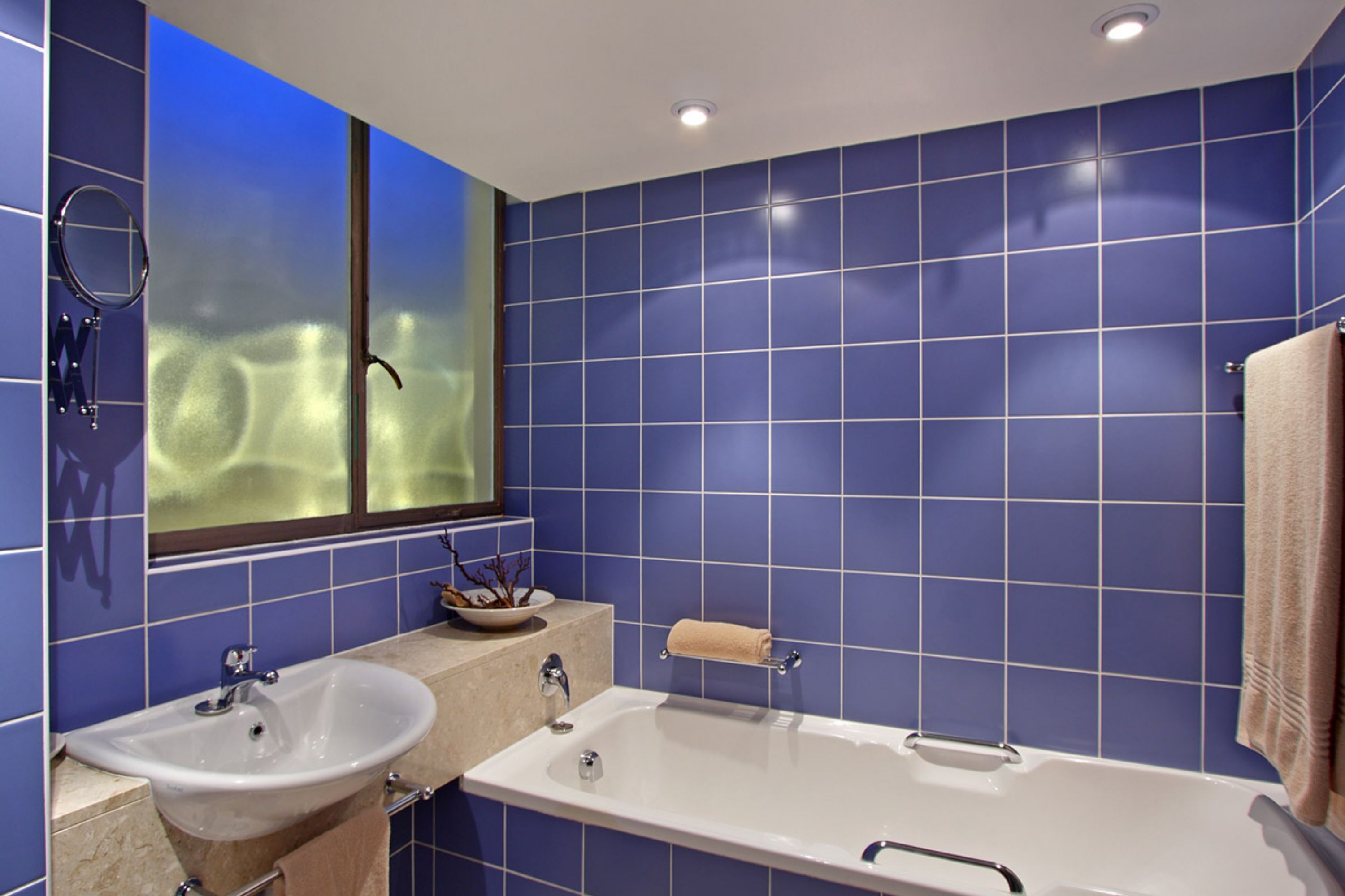A bathroom with two sinks, a bathtub, and a window with a view.