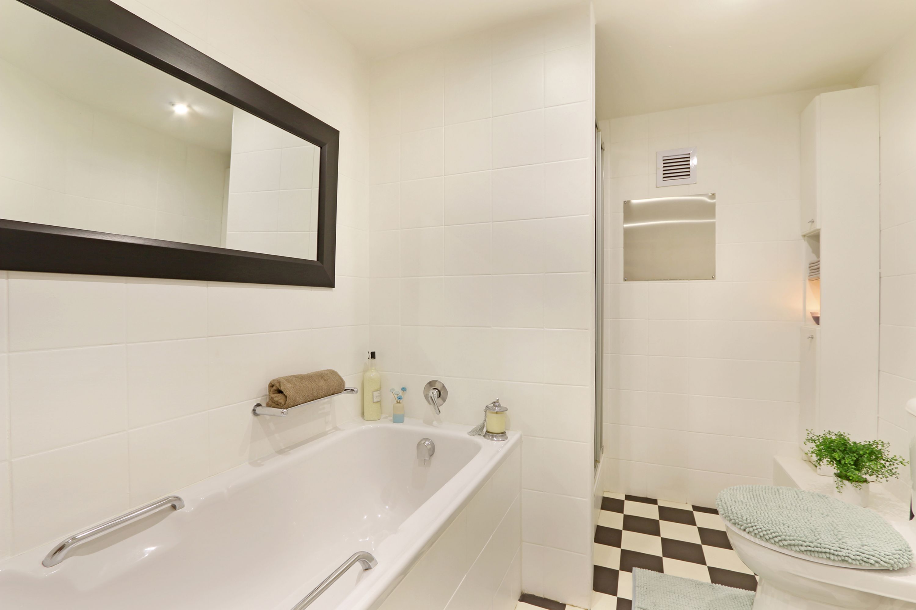 Een moderne badkamer met bad, toilet en douche.