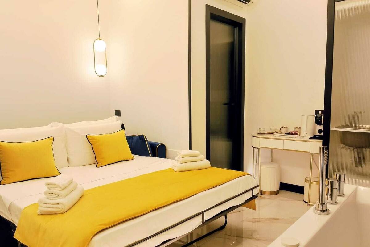 A hotel room with a bed, a desk, and a bathroom.