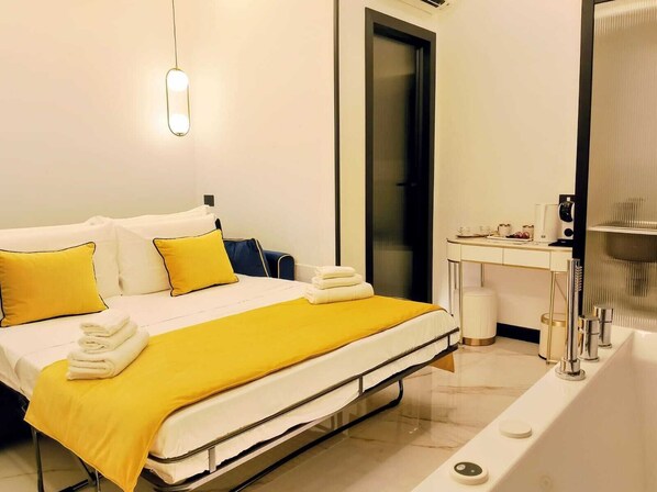 A hotel room with a bed, a desk, and a bathroom. - Incanto Suites Italy (Naples)