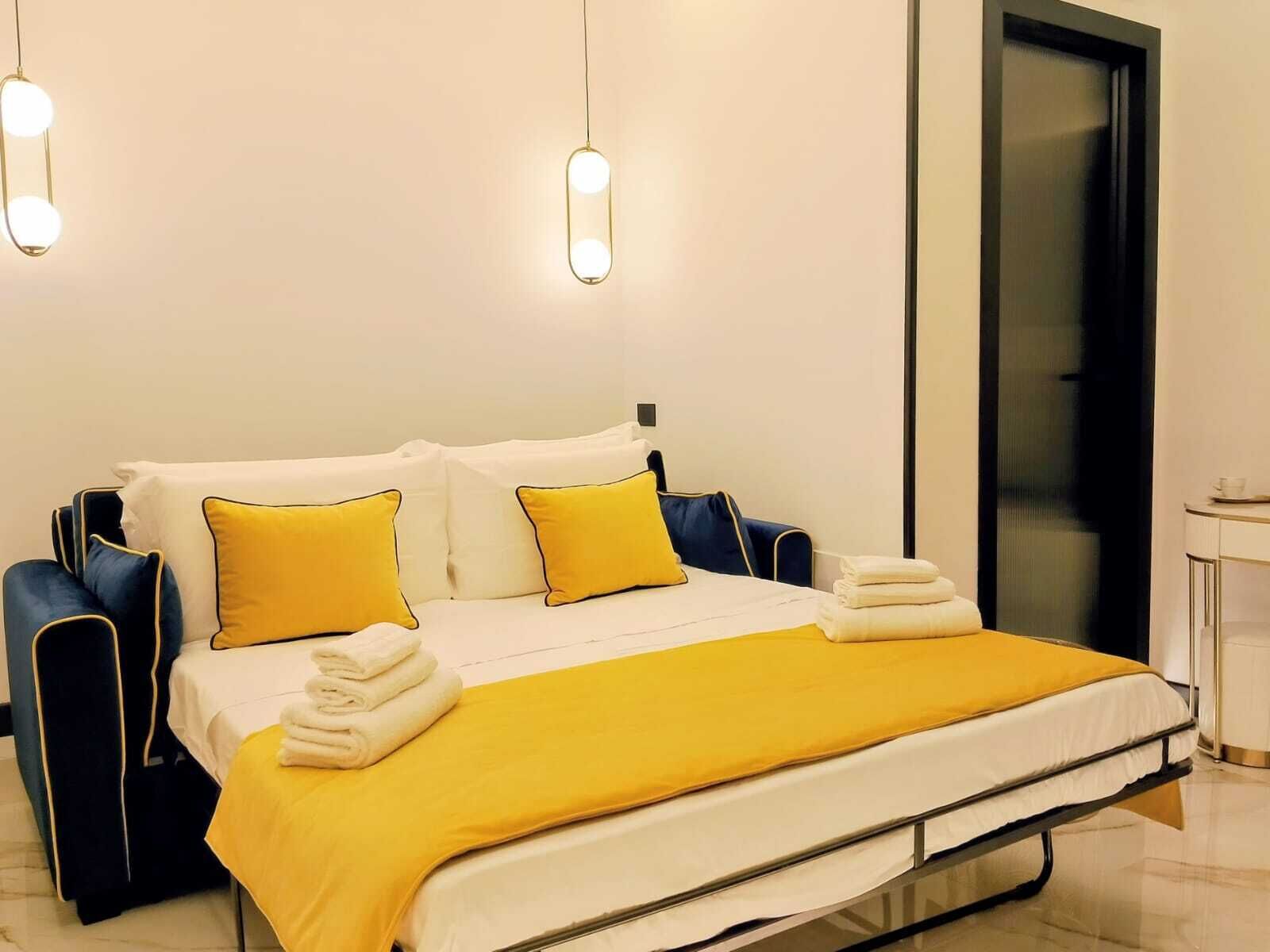 Una habitación de hotel moderna con cama, mesitas de noche y una puerta.