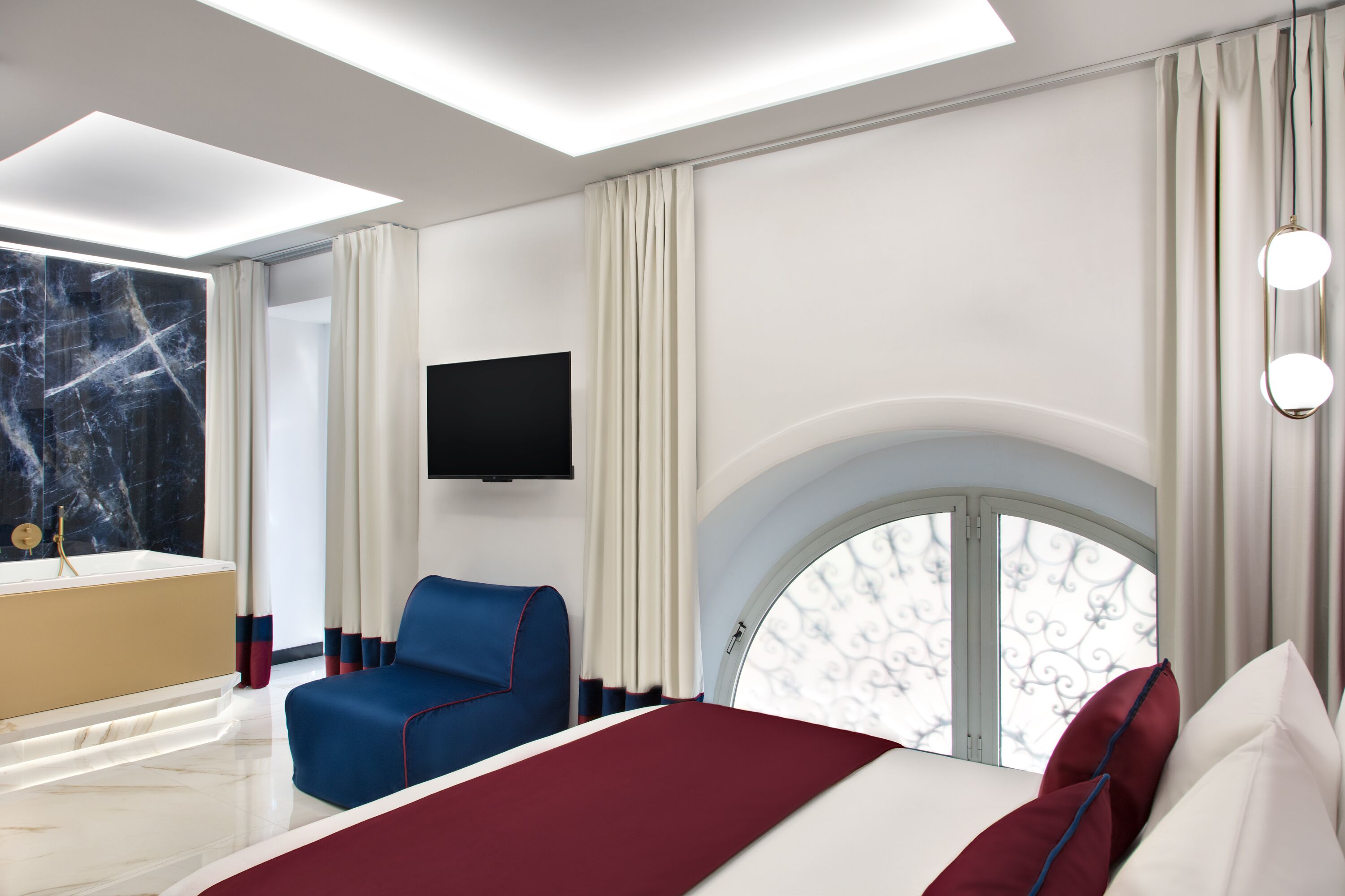 Une chambre d’hôtel moderne dotée d’un grand lit, d’un coin salon, d’une télévision et d’une fenêtre offrant une vue agréable.