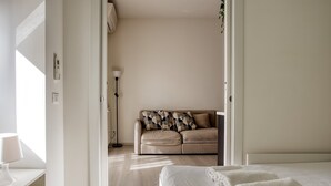 Habitació d'hotel moderna amb un llit, un sofà i una taula de nit.