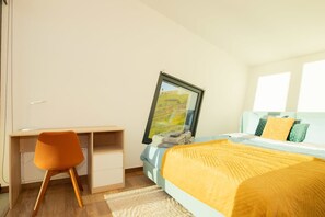 A bedroom with a bed, a desk, and a chair. - Villa Leonor Cliffside Retreat (Calheta)