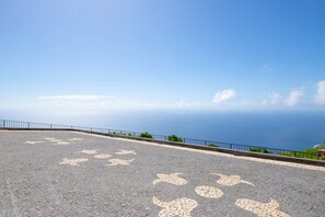 A paved area with a railing and a view of the ocean. - Villa Leonor Cliffside Retreat (Calheta)