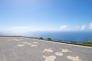 A paved area with a railing and a view of the ocean. - Villa Leonor Cliffside Retreat (Calheta)