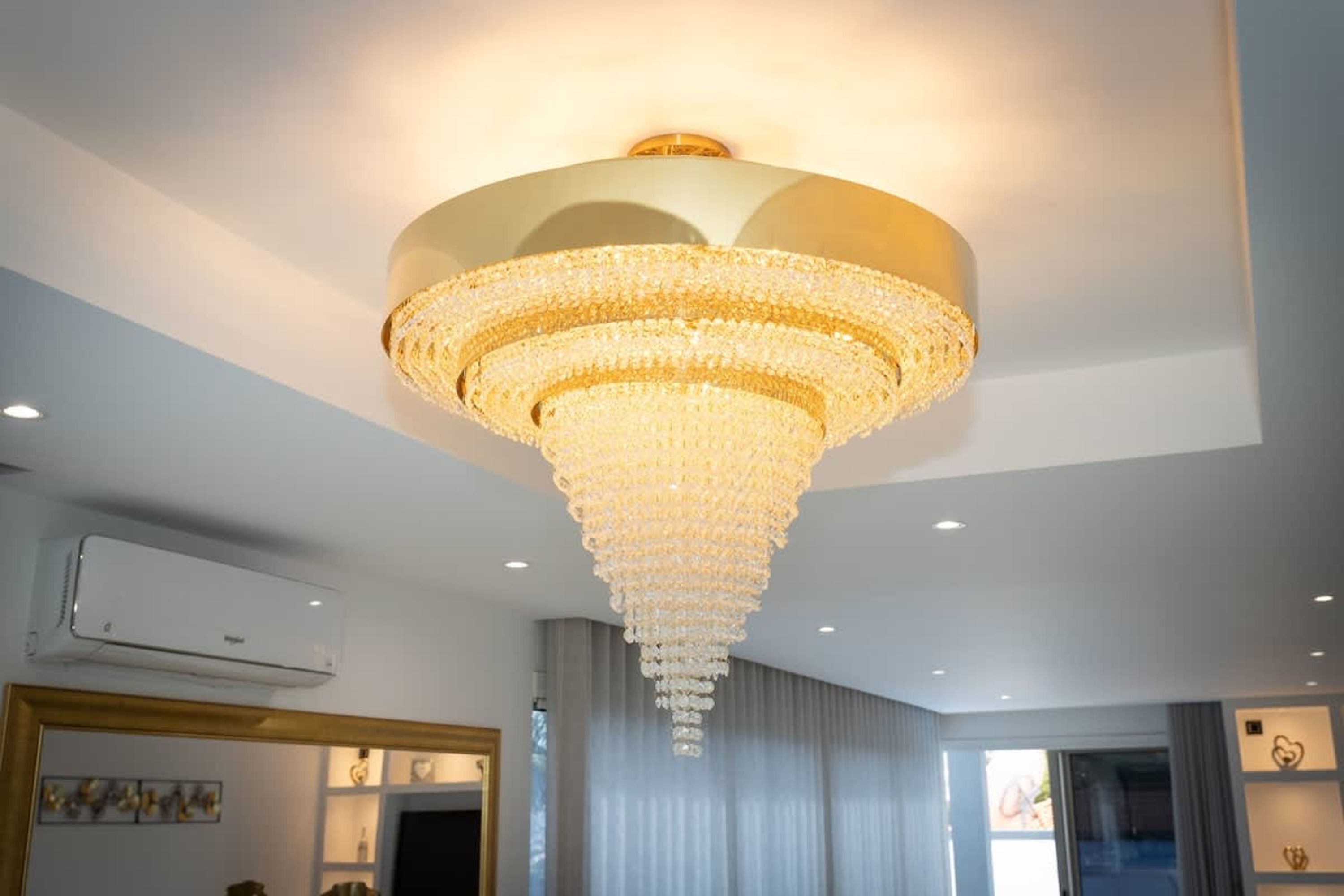 Un lustre composé de plusieurs niveaux de cristaux suspendus au plafond.