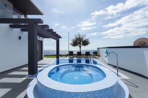 Une piscine sur le toit offrant une vue dégagée sur le ciel et les palmiers.