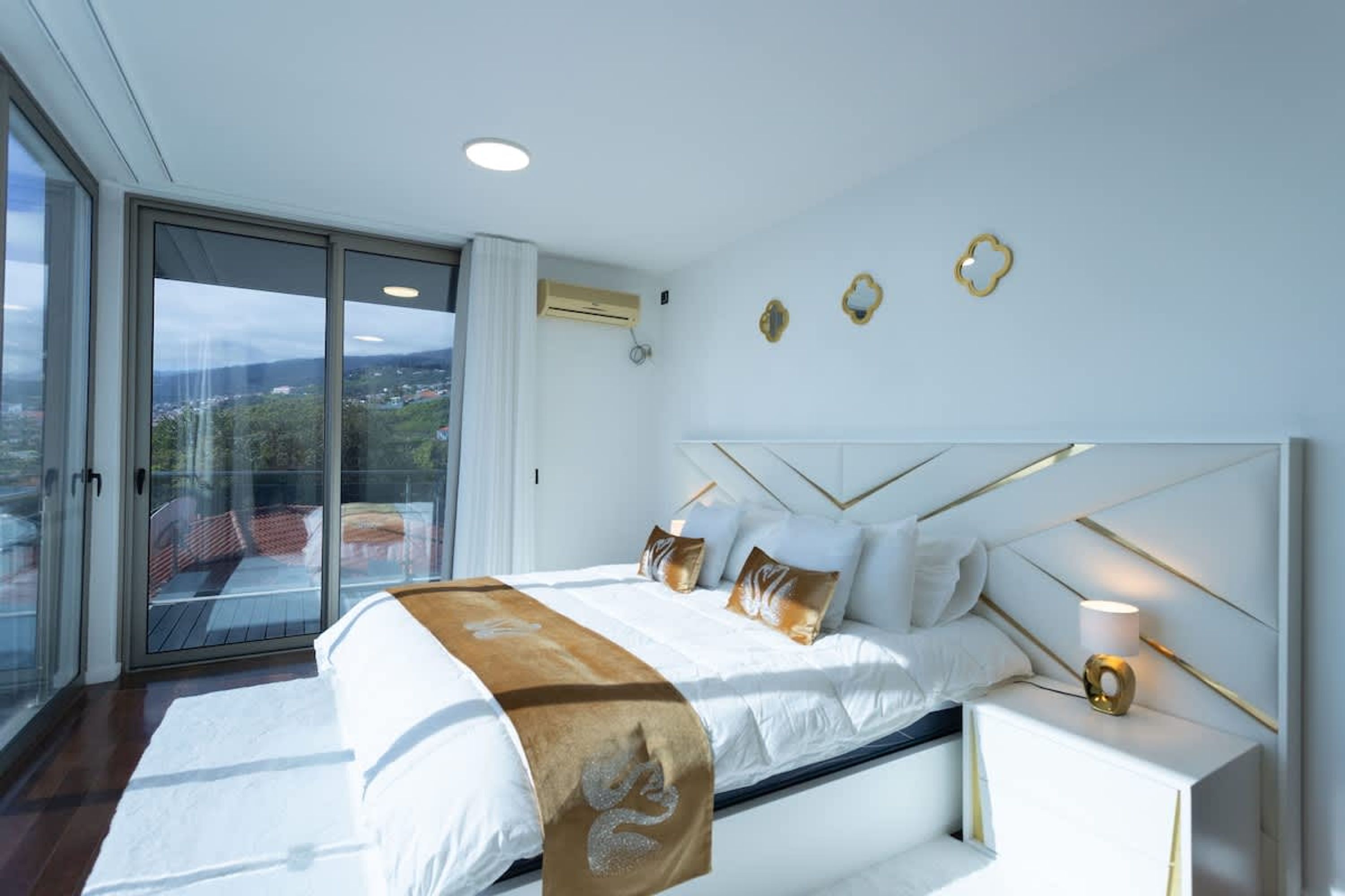 Un dormitorio moderno con una cama grande, una mesita de noche y vistas a través de un ventanal corredero.