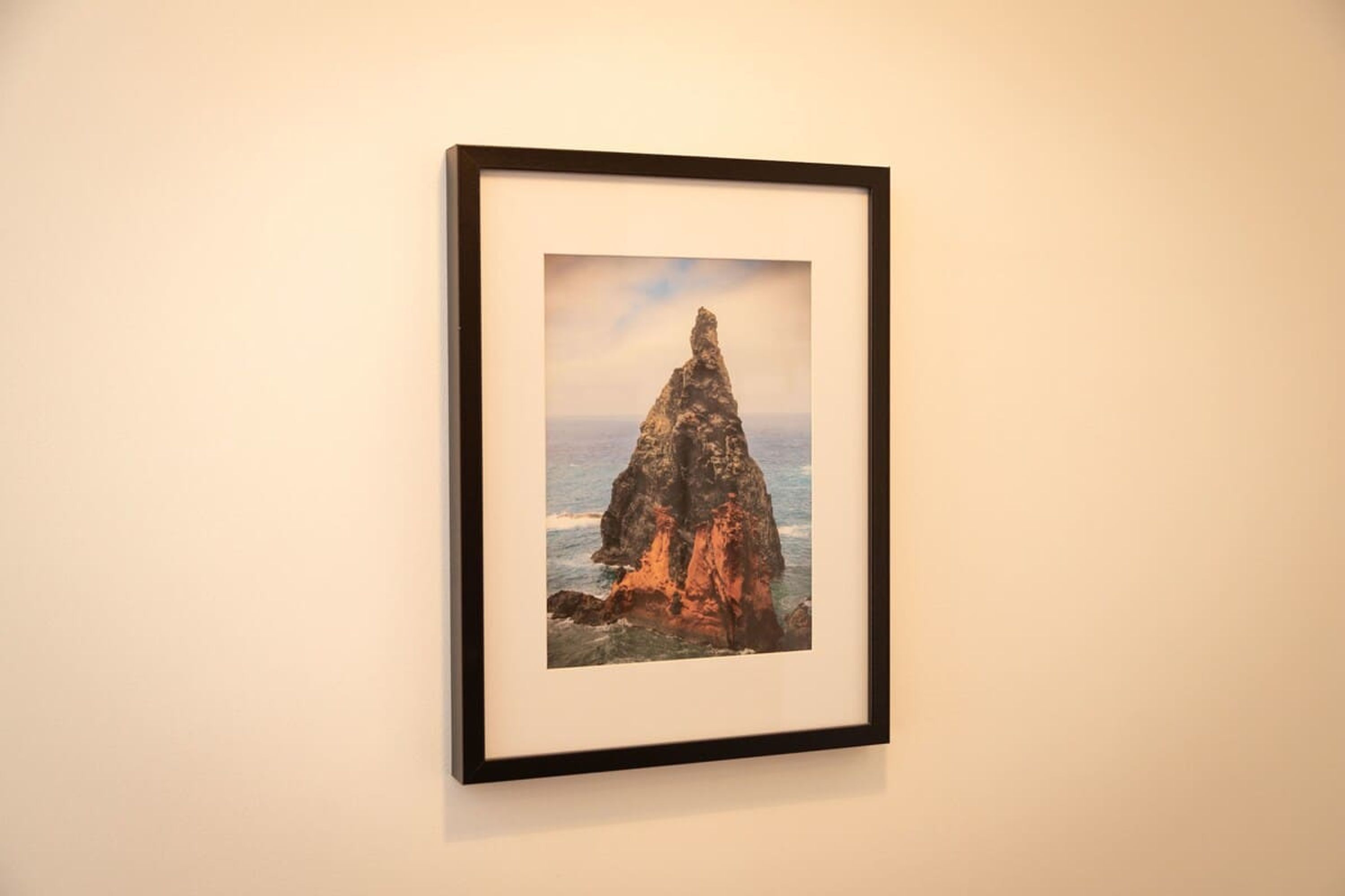 A framed photograph of a coastal rock formation.