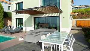 A modern two-story house with a swimming pool, outdoor seating area, and a covered patio. - Villa Eden Nature in Prazeres (Calheta)