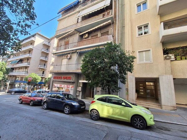 A multi-story building with balconies and a shop on the ground floor.