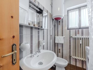 Un bagno moderno con lavabo, WC e doccia.