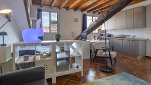 A modern kitchen with white cabinets, a dining area with a table and chairs, and a large window providing natural light. - Beautiful apartment for 2 people with A/C, WIFI and TV (Milan)