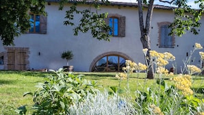 Un bâtiment blanc avec des fenêtres en arc et une entrée en briques.