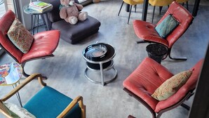 Un interior moderno con comedor, diferentes opciones de asientos y vistas por una ventana grande.