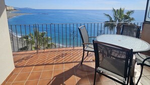A balcony with a view of the sea, a table, chairs, and a railing. - Spectacular beachfront. 3 bedrooms very central. (Almuñécar)