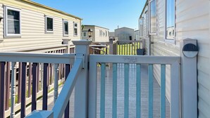 A gated walkway leading to mobile homes with a clear sky above.