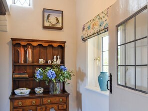A wooden dresser with decorative items and a vase of flowers.