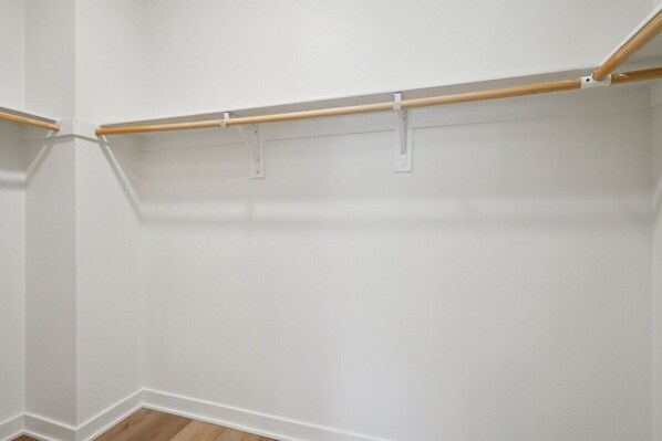 A corner of a room with white walls and a wooden floor.