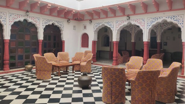 A traditional courtyard with patterned furniture and checkered flooring. - Heritage Lotwara Fort (Baswa)