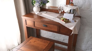 A wooden vanity with a mirror, a small table, and a vase with flowers. - Q-Zen House Cunda (Ayvalik)