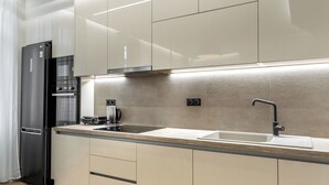 A modern kitchen with a stainless steel refrigerator, a built-in oven, and a double sink. - J&A Luxury Residence (Athens)