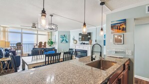 A modern kitchen with granite countertops, a built-in oven, and a large island. - Includes Xplorie Activities & Linens. PYRAMID-2BR OFcondo w/outdoor pool. (Ocean City)