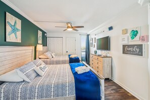 A bedroom with two beds, a ceiling fan, a TV, and motivational wall art. - Includes Xplorie Activities & Linens. PYRAMID-2BR OFcondo w/outdoor pool. (Ocean City)