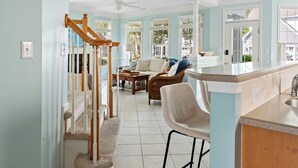 Amplia sala de estar con cocina, escalera y vistas al exterior.