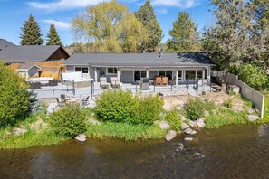 Situated by the river, this lodge offers a tranquil setting with a covered patio and outdoor seating.