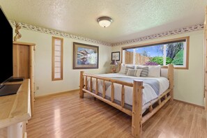 Cozy retreat with a comfortable bed, desk, and window offering a view of the outdoors.