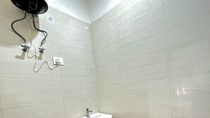 Un baño pequeño con inodoro, lavabo y ducha.