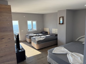 Habitación cuádruple de lujo, vista al mar | Wifi gratis y ropa de cama 