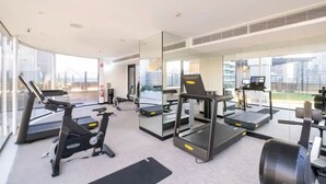A modern gym with treadmills, stationary bikes, and weight machines.