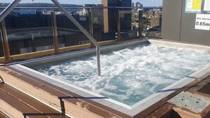 A rooftop hot tub with a view of the city skyline.